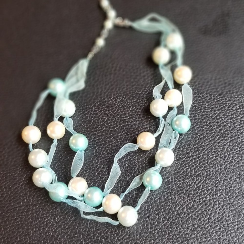 light blue necklace with perals on chiffon